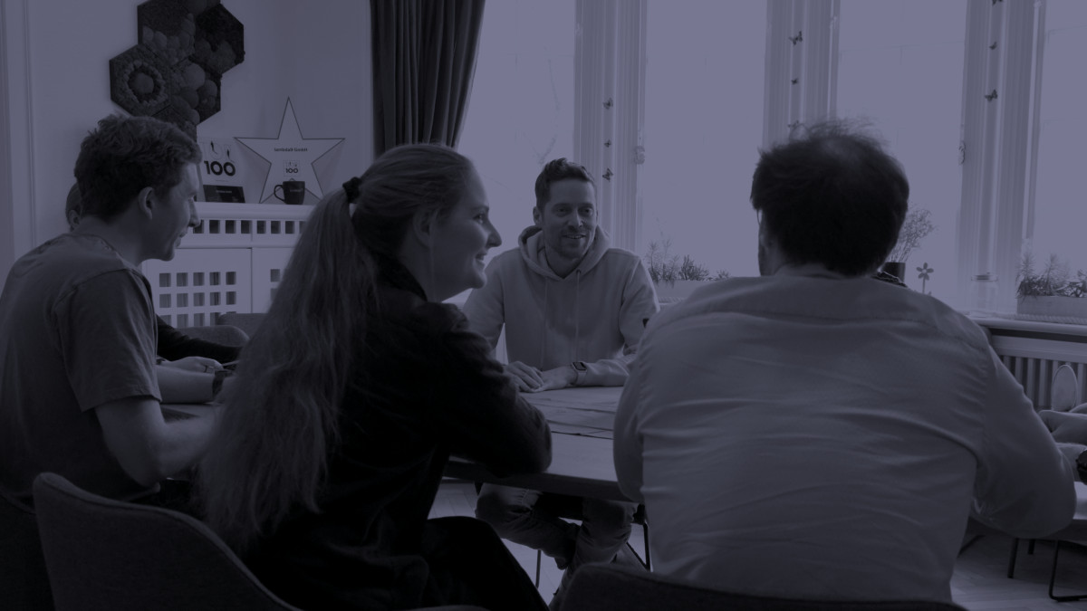 Menschen sitzen gemeinsam am Tisch und diskutieren.