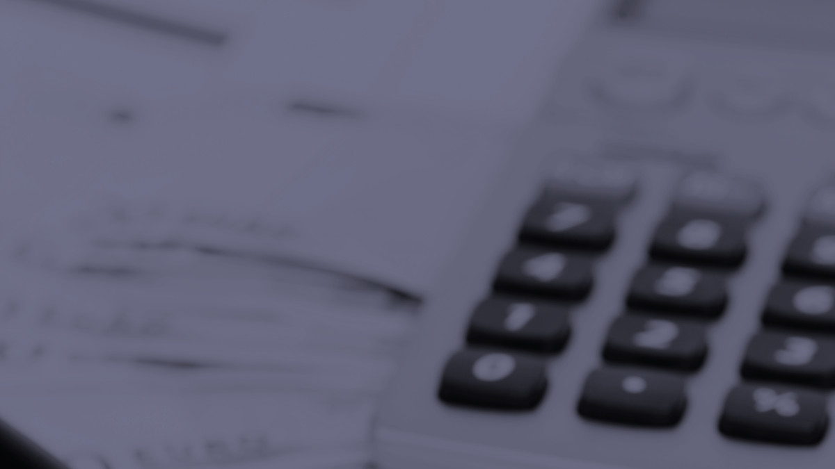 Ein Taschenrechner und Dokumente liegen auf einem Schreibtisch